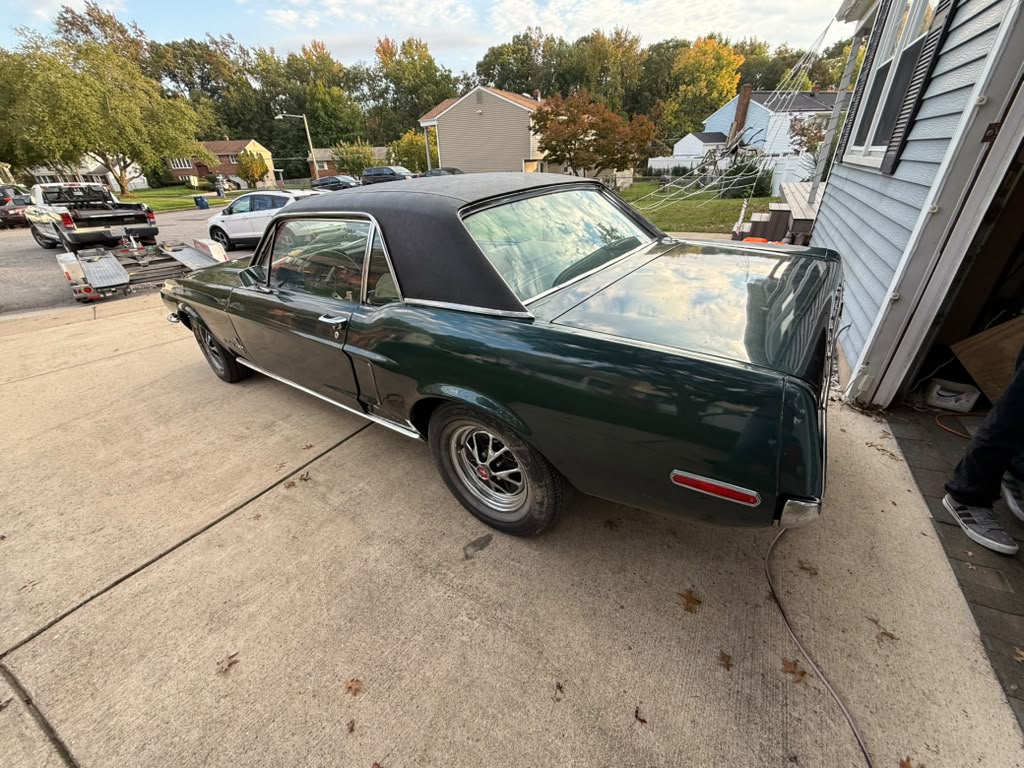 Ford Mustang 1968 coupé met zwart vinyldak, net voor het laden op de trailer